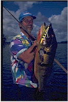 National Freshwater Fishing Hall of Famer Spence Petros of Chicago admires a trophy 18 pound tucunare (the Brazilian term for peacock bass). 