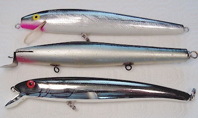 Hand holding a Fishing lure with single hook imitating a sand eel